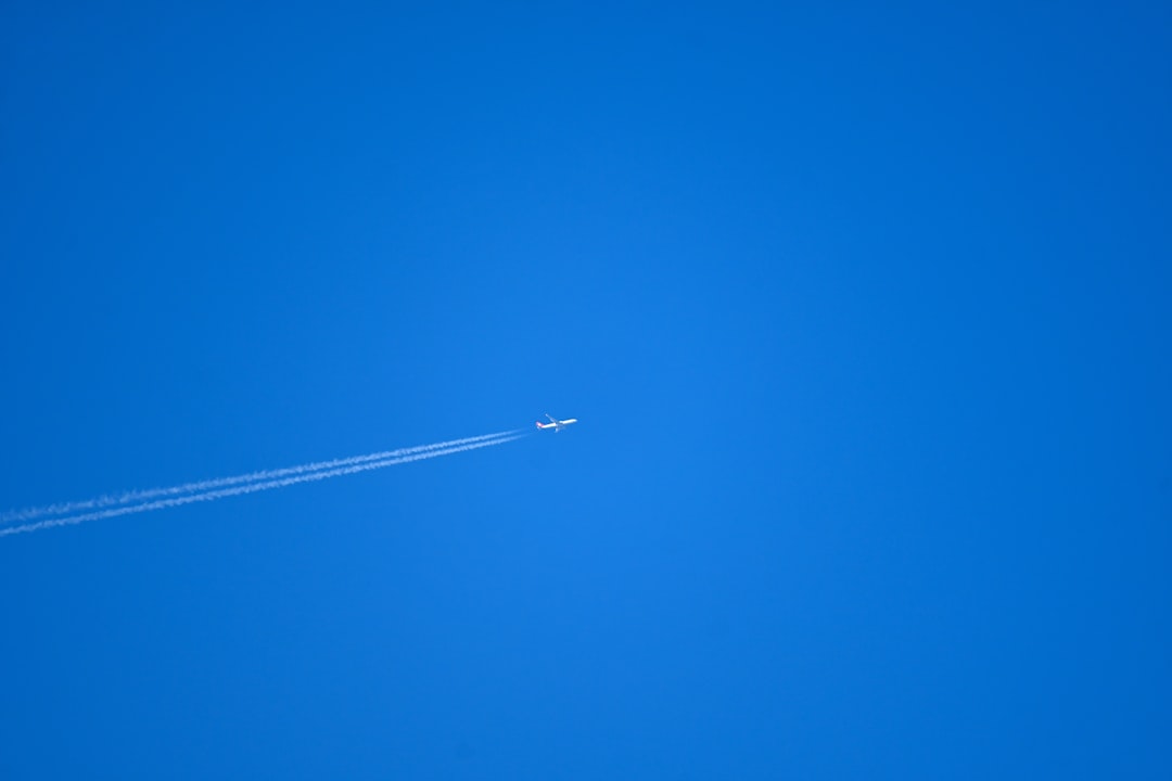 An airplane is flying in the blue sky