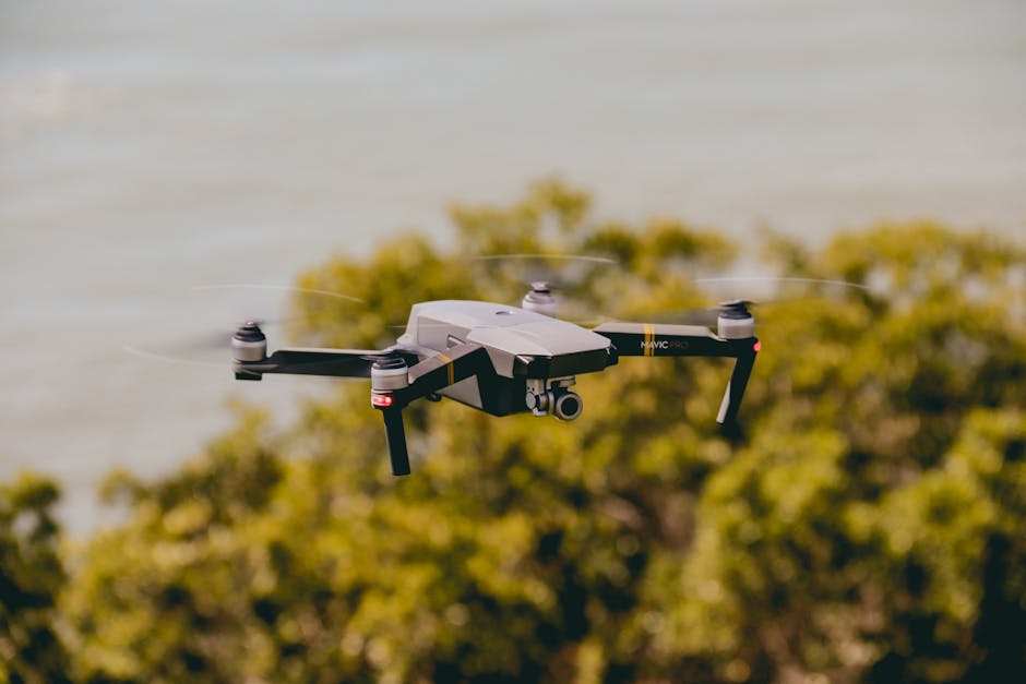 Aerial view of a drone flying over lush greenery and water, capturing stunning outdoor scenes.