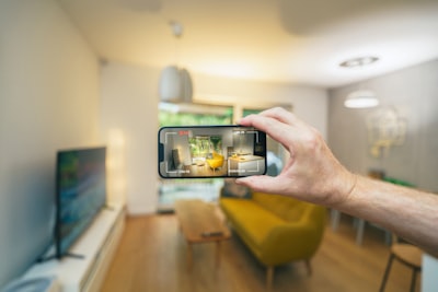 person holding smartphone filming interior of house