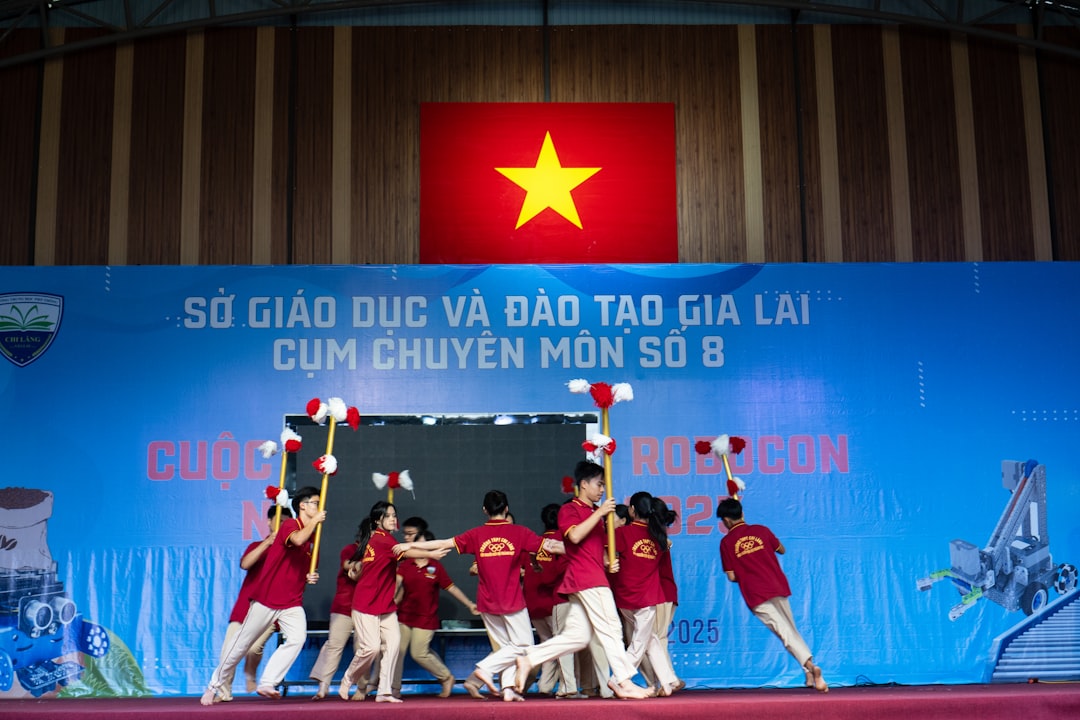 Students perform on stage with a vietnamese flag.