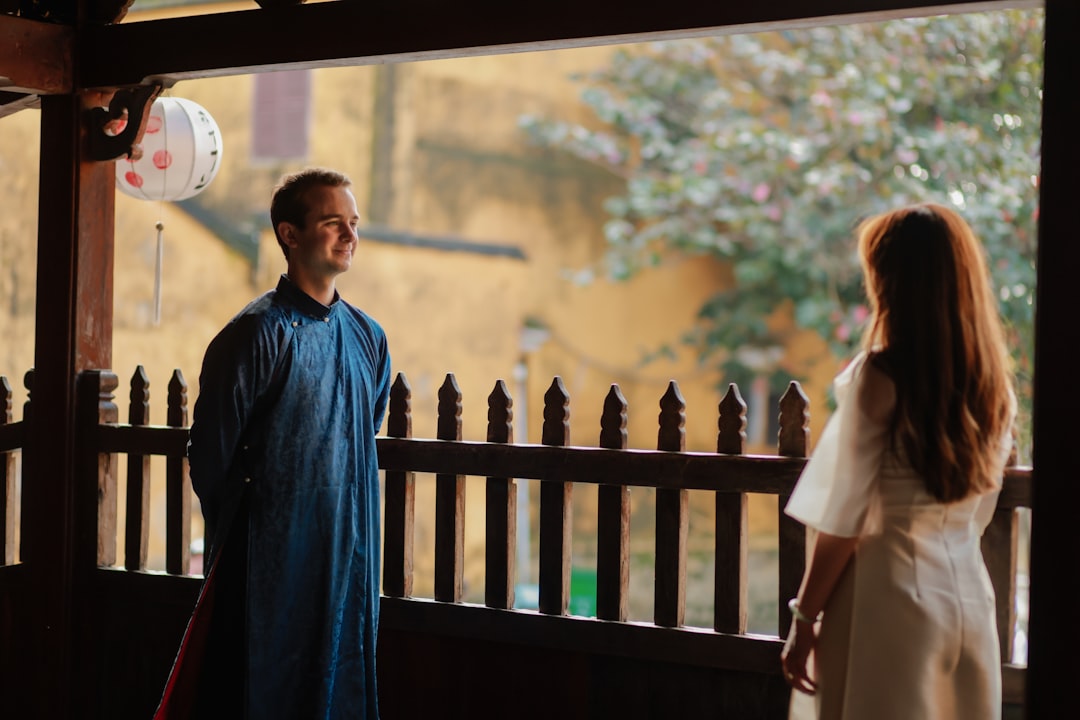 Man and woman standing on a wooden balcony.
