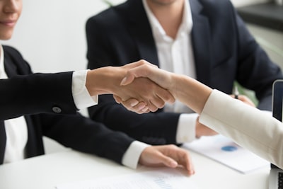 business people shaking hands after successful negotiation, contract on table