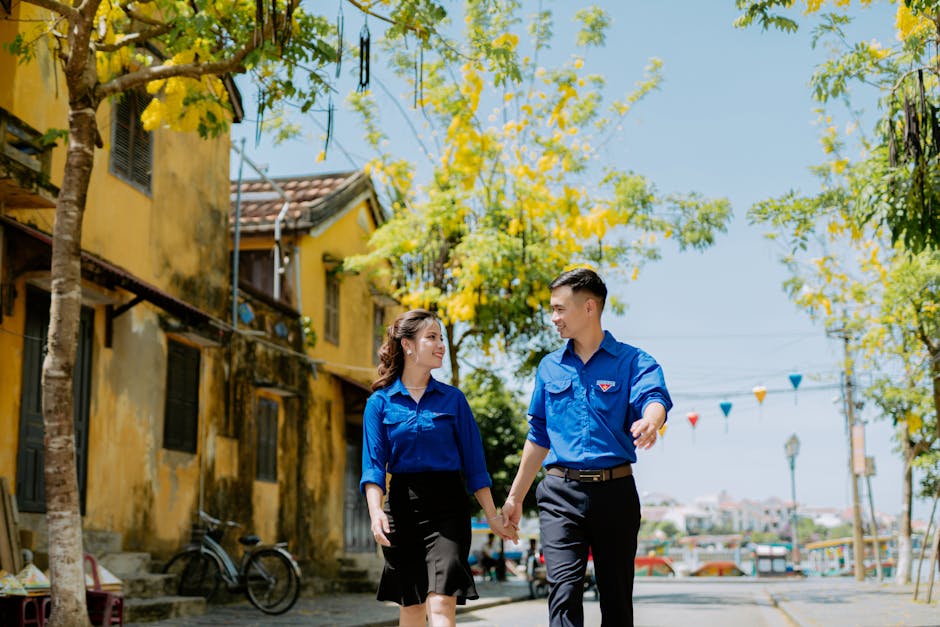 Asian couple walking hand in hand on a sunny street, capturing romance and happiness.