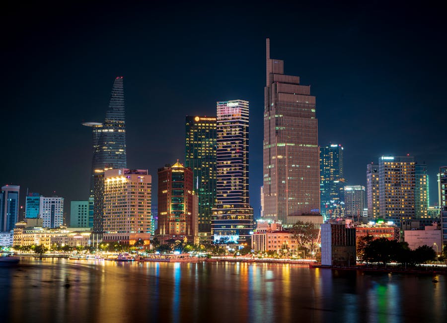 Stunning night view of the illuminated Ho Chi Minh City skyline reflecting on the water.