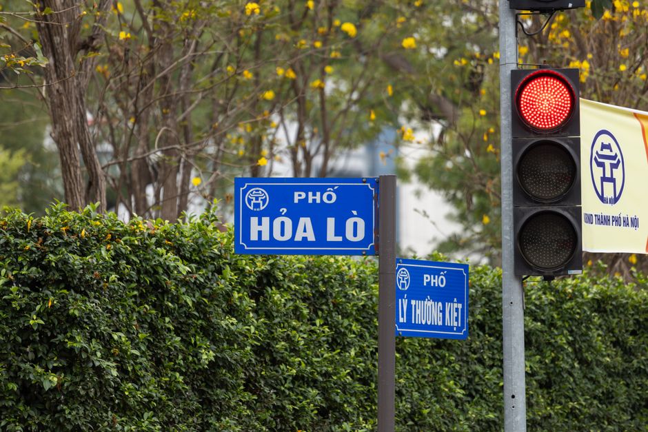 Photograph of street signs and a traffic light on Hòa Lò Street in Hà Nội, Vietnam.