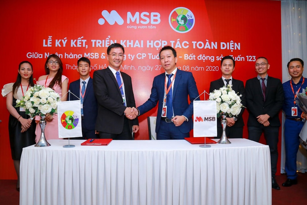 Two businessmen shaking hands at a signing ceremony event.