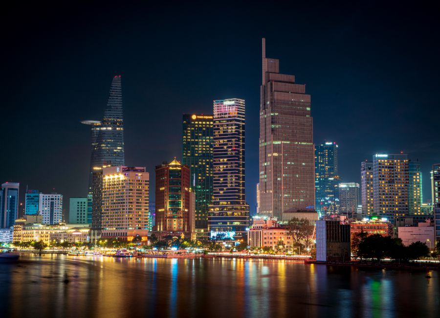 Stunning night view of the illuminated Ho Chi Minh City skyline reflecting on the water.