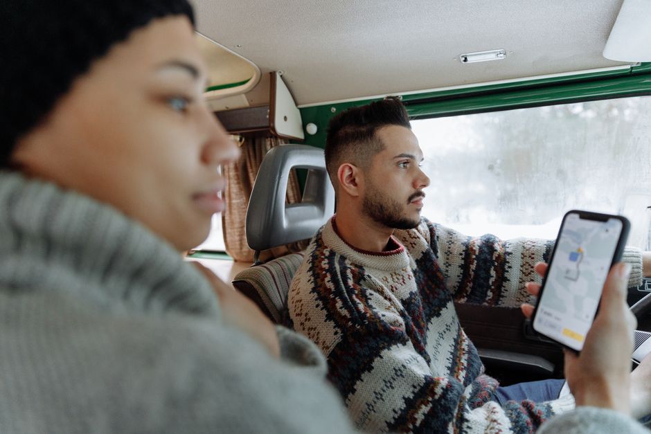 Couple using navigation app in a vintage campervan during a road trip.