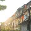 a row of apartment buildings with colorful flags hanging from the balconies