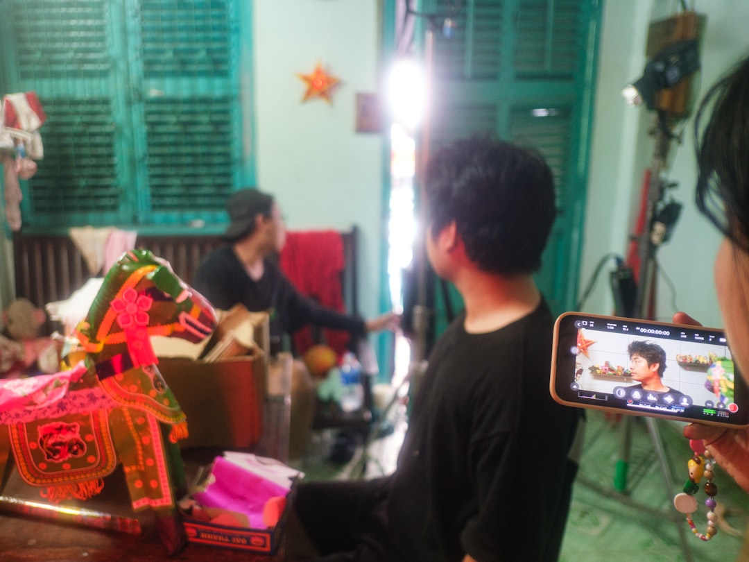 Smartphone filming a person and traditional horse in a room.