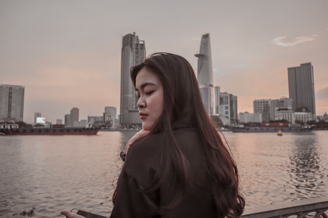 a woman standing next to a body of water