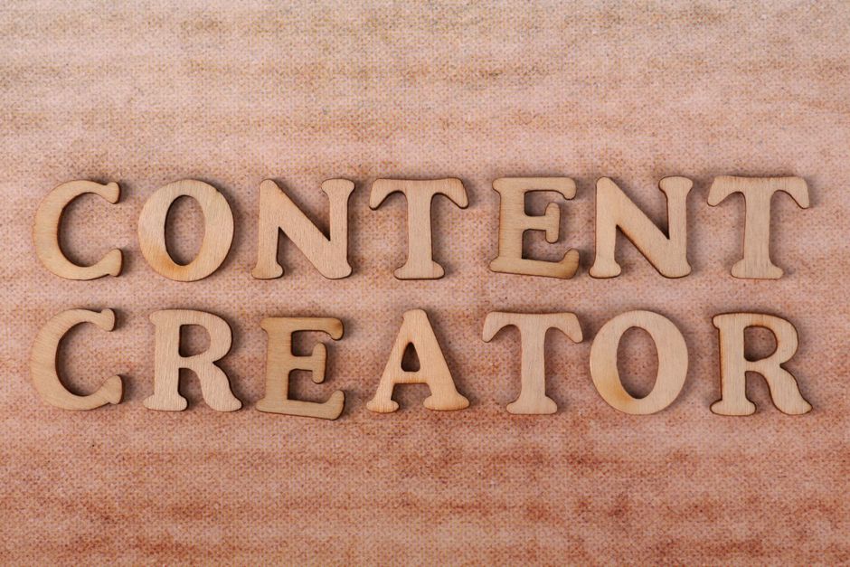 Wooden letters form 'Content Creator' on textured fabric background.