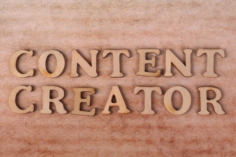 Wooden letters form 'Content Creator' on textured fabric background.