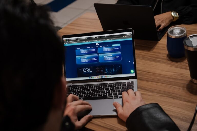 Hands typing on a laptop displaying a web interface
