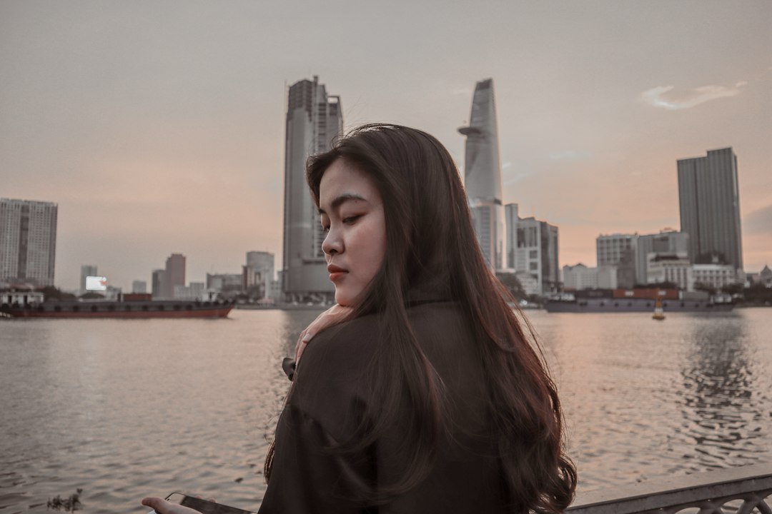 a woman standing next to a body of water