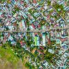 Aerial shot of a colorful urban neighborhood, showcasing tightly packed houses and greenery.
