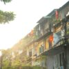 a row of apartment buildings with colorful flags hanging from the balconies